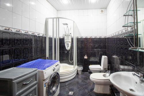 uma casa de banho com um chuveiro e uma máquina de lavar roupa. em Funicular Apartments em Tbilisi