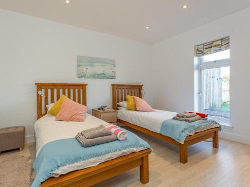 a bedroom with two beds and a window at Woodend Barn in Auchterarder