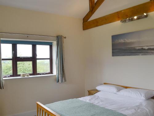 1 dormitorio con 2 camas y ventana en The Barn - Ukc3750, en Charmouth
