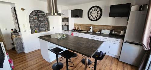 a kitchen with a table and a clock on the wall at Le Faust in Valence
