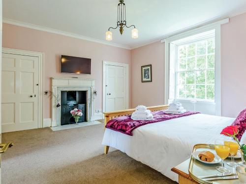 a bedroom with a bed and a fireplace at Lode Hall in Upwell