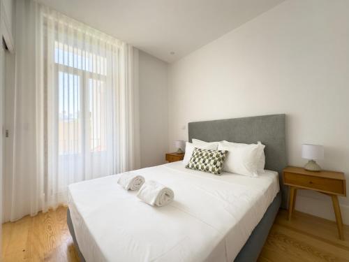 biała sypialnia z dużym łóżkiem i oknem w obiekcie Vibrant Porto Apartments-Bonfim w Porto