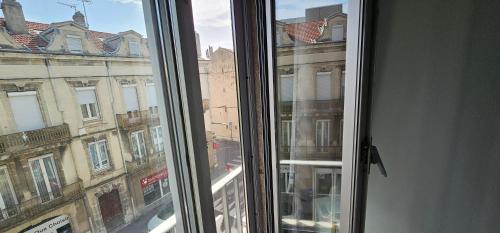 a window with a view of a building at Le Faust in Valence