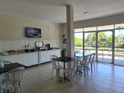 a kitchen and dining room with a table and chairs at Hotel Ouro Preto in João Pessoa