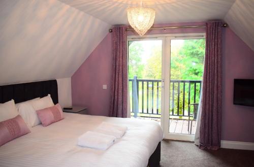 a bedroom with a bed and a large window at Inglewood House and Spa in Alloa