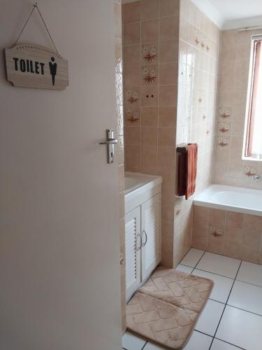 a bathroom with a tub and a toilet and a sink at Serenity Shores Backpackers in Cape Town