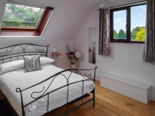 a bedroom with a bed and two windows at Elm Loft in Upton