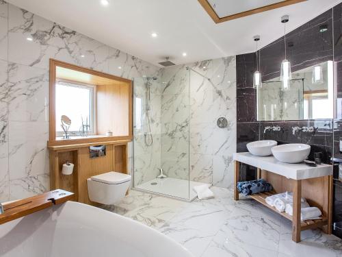 a bathroom with a tub and two sinks and a shower at Morven View in Dunbeath