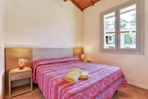 a bedroom with a bed and a window at Villaggio Le Venelle in Rio Marina