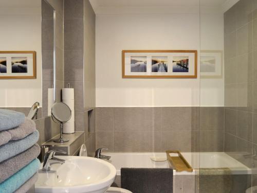 a bathroom with a sink and a bath tub at The Nook in Woolacombe