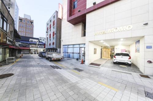 an empty street in a city with cars parked at Hotel MoMo in Busan