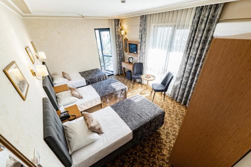 a hotel room with two beds and a couch at Hamit Hotel Kizilay in Ankara