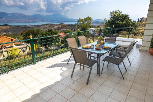 a patio with a table and chairs on a balcony at Villa Theano - Family House in Lixouri, Kefalonia in Lixouri