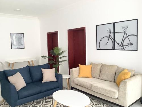 a living room with two couches and a bike on the wall at Lekki FootPrint, Lekki Phase1 in Lekki
