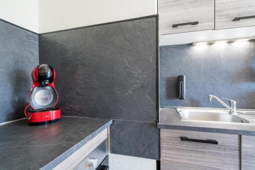 une cuisine avec un mixeur rouge assis sur un comptoir dans l'établissement Le Stanny - 2 lits - 4 pers' - parking - Streaming, à Metz