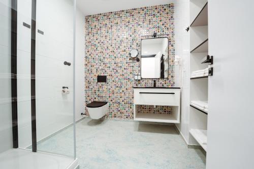 y baño con aseo y espejo. en Family Apartments by ASTORIA Hotel & Medical Spa en Karlovy Vary