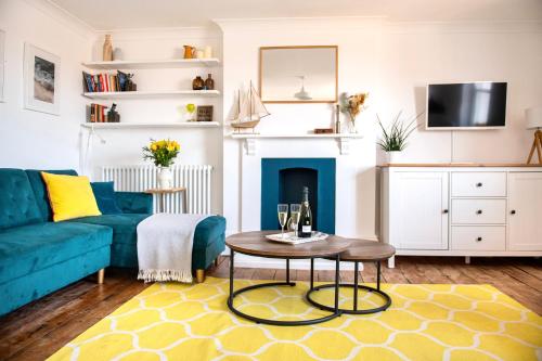 a living room with a blue couch and a table at Central, Seaview Apartment, 3 beds, 2 baths, kid & dog friendly at The Lookout Broadstairs in Broadstairs