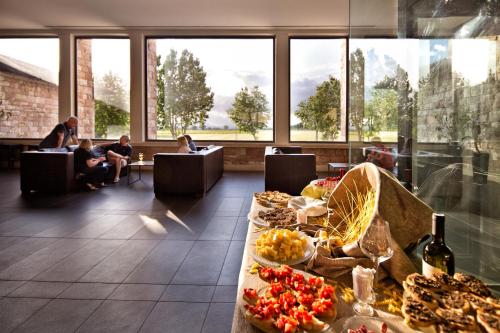 eine Lobby mit einem Tisch voller Essen und Menschen sitzen in der Unterkunft TH Assisi - Hotel Cenacolo in Assisi