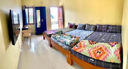 uma sala de estar com duas camas e um sofá em White House em Kodaikanal