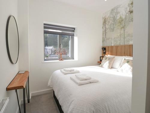 a bedroom with a bed with two towels on it at Watch Tree Apartment in Ulverston