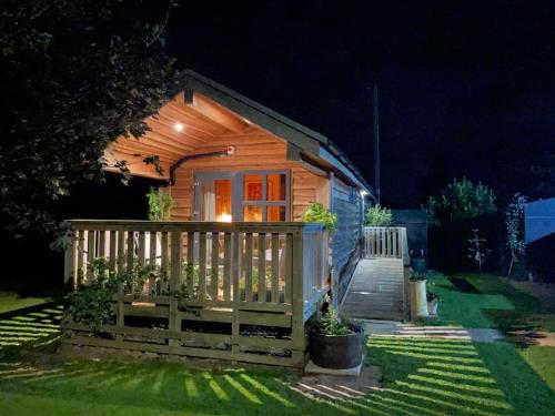 uma pequena cabana com cerca e escadas à noite em The Firkin Lodge em Whaplode