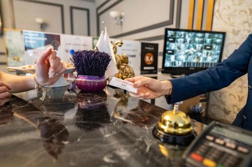 a person handing a credit card to a customer at a counter at Hamit Hotel Kizilay in Ankara