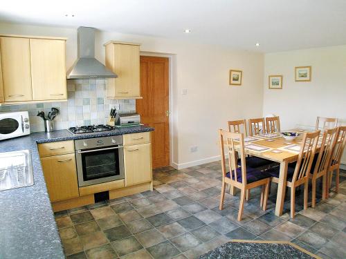 a kitchen with a table and a stove top oven at Whitehouse Cottage in Skipton
