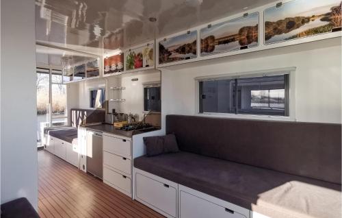 a kitchen with white cabinets and a bench in a tiny house at Beautiful Ship In Havelsee With House Sea View in Kützkow