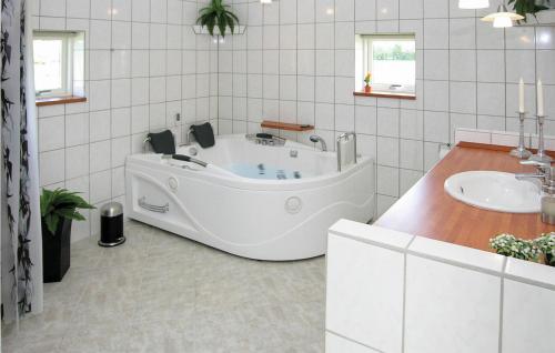 een badkamer met een ligbad en een wastafel bij 4 Bedroom Gorgeous Home In Tarm in Hemmet