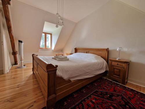 ein Schlafzimmer mit einem großen Bett und einem Teppich in der Unterkunft Maison Normande - Cosy - Haras du Pin à 30' in Fay