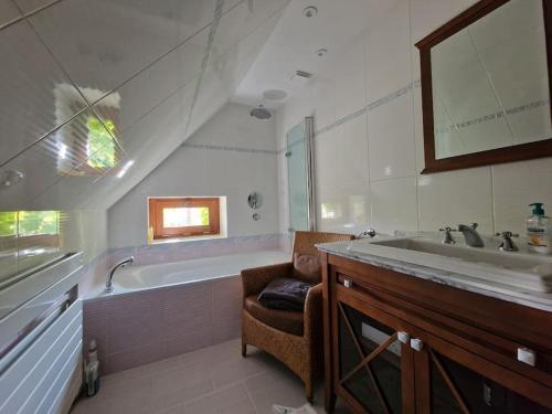 un bagno con vasca e lavandino di Maison de charme pour 4 personnes, calme a Fay