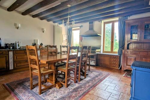 une grande cuisine avec une table et des chaises en bois dans l'établissement Maison Normande - Cosy - Haras du Pin à 30', à Fay