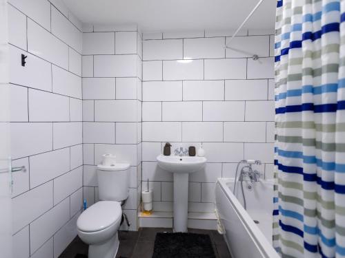 Baño blanco con aseo y lavamanos en 3 bedrooms House with nice park view en Thamesmead