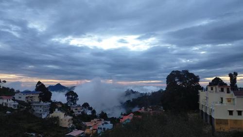 uma vista para uma cidade com nuvens no céu em White House em Kodaikanal