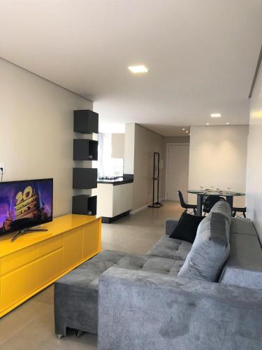 a living room with a gray couch and a yellow cabinet at Dallas apartamentos na Via Gastronômica-Estacionamento-Amplos e equipados-Wifi in Bento Gonçalves