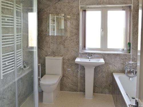 a bathroom with a toilet and a sink and a shower at Harbour Hill in Chickerell