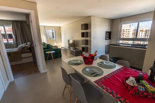 a kitchen and living room with a table and chairs at 4 Apartamentos amplos e novos, 86m e 45m, excelente localização, garagem, 350Mb de internet in Bento Gonçalves