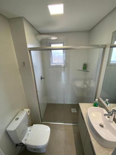 a bathroom with a shower and a toilet and a sink at Dallas apartamentos na Via Gastronômica-Estacionamento-Amplos e equipados-Wifi in Bento Gonçalves