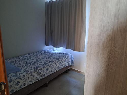 un petit lit dans une chambre avec une fenêtre dans l'établissement Charmoso apto villamares, à Luis Correia