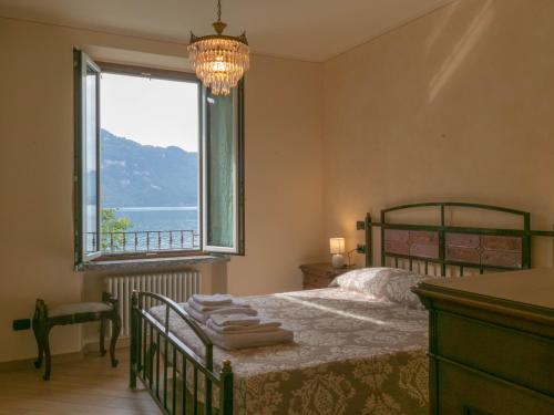 a bedroom with a bed and a large window at Villa Roberta in Mandello del Lario