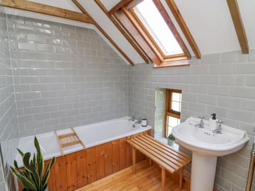 a bathroom with a bath tub and a sink at Nanthir House in Llandrindod Wells