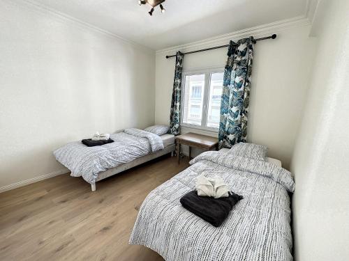 une chambre avec deux lits et une fenêtre dans l'établissement BOU3 - Appartement climatisé, 2 chambres à quelques mètres de la Croisette, à Cannes