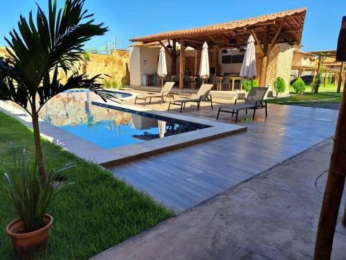 un patio avec des chaises et une piscine dans une maison dans l'établissement Charmoso apto villamares, à Luis Correia