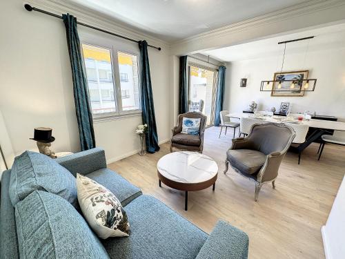 - un salon avec un canapé bleu, des chaises et une table dans l'établissement BOU3 - Appartement climatisé, 2 chambres à quelques mètres de la Croisette, à Cannes