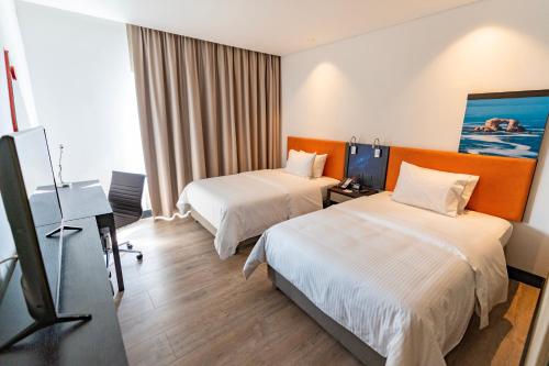 a hotel room with two beds and a television at Hampton By Hilton Antofagasta in Antofagasta
