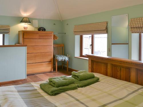 a bedroom with a large bed with green pillows on it at Gardeners Cottage - Ukc4299 in Littleham