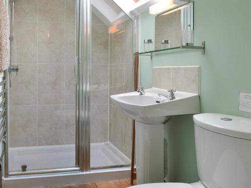 a bathroom with a shower and a sink and a toilet at Gardeners Cottage - Ukc4299 in Littleham