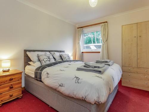 a bedroom with a large bed and a window at Chesnut Cottage in Banavie