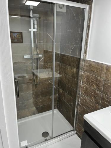 a shower with a glass door in a bathroom at Yu’s Guest House in Sevenoaks