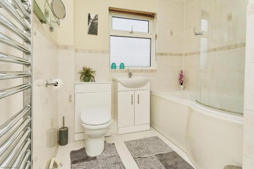 een badkamer met een toilet, een wastafel en een bad bij 3 Harbour Strand in Bembridge